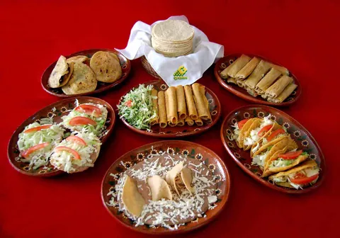 Mesa con platillos preparados con tortillas de maíz: flautas, tostadas, sopes y gorditas