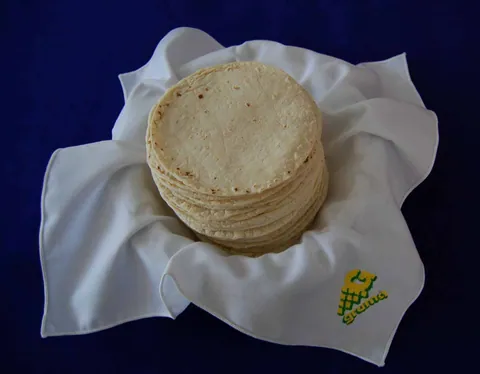 Montón de tortillas de maíz recién hechas sobre un lienzo blanco