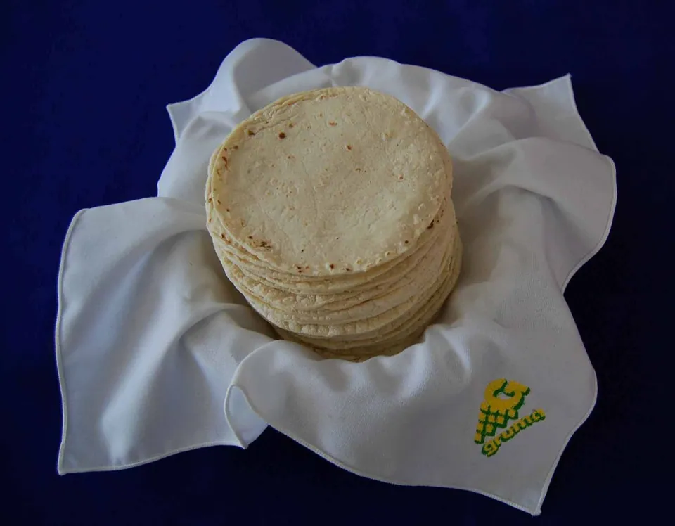 Montón de tortillas de maíz recién hechas sobre un lienzo blanco