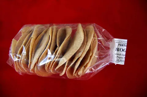 Paquete de tostadas de maíz con la etiqueta de Tortillerías Progreso